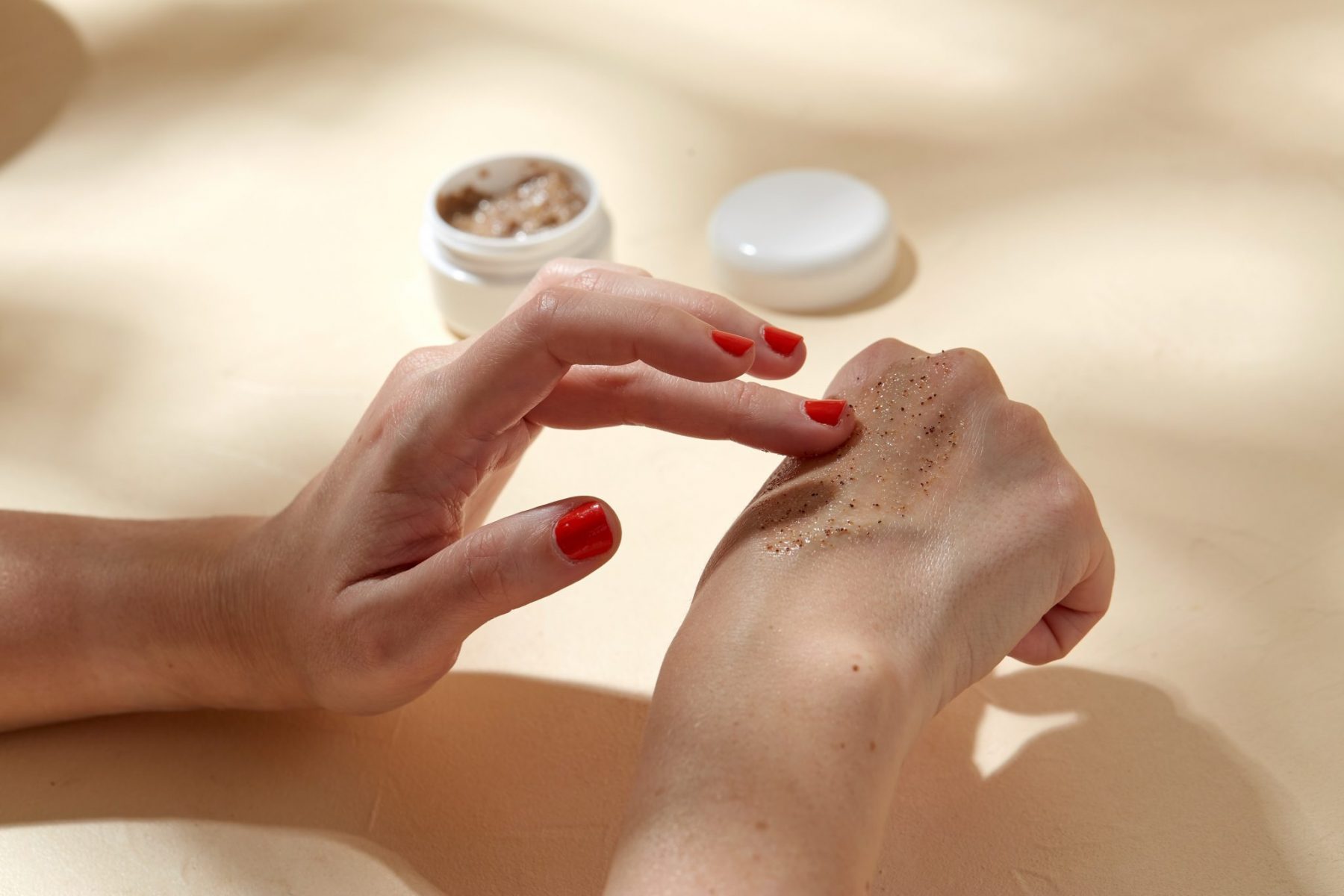 A women is applying body scrub on her hands